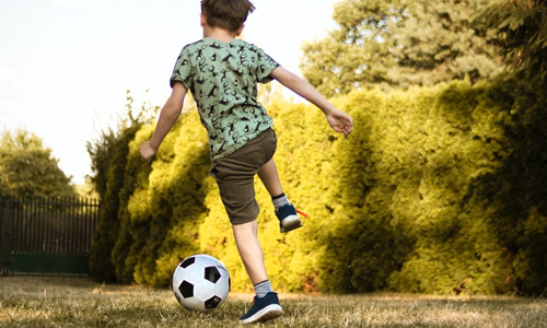 Boy playing football outside