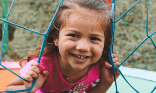 Girl playing on outdoor equipment