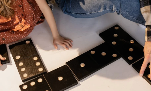 Girl and grandpa learning with giant dominoes