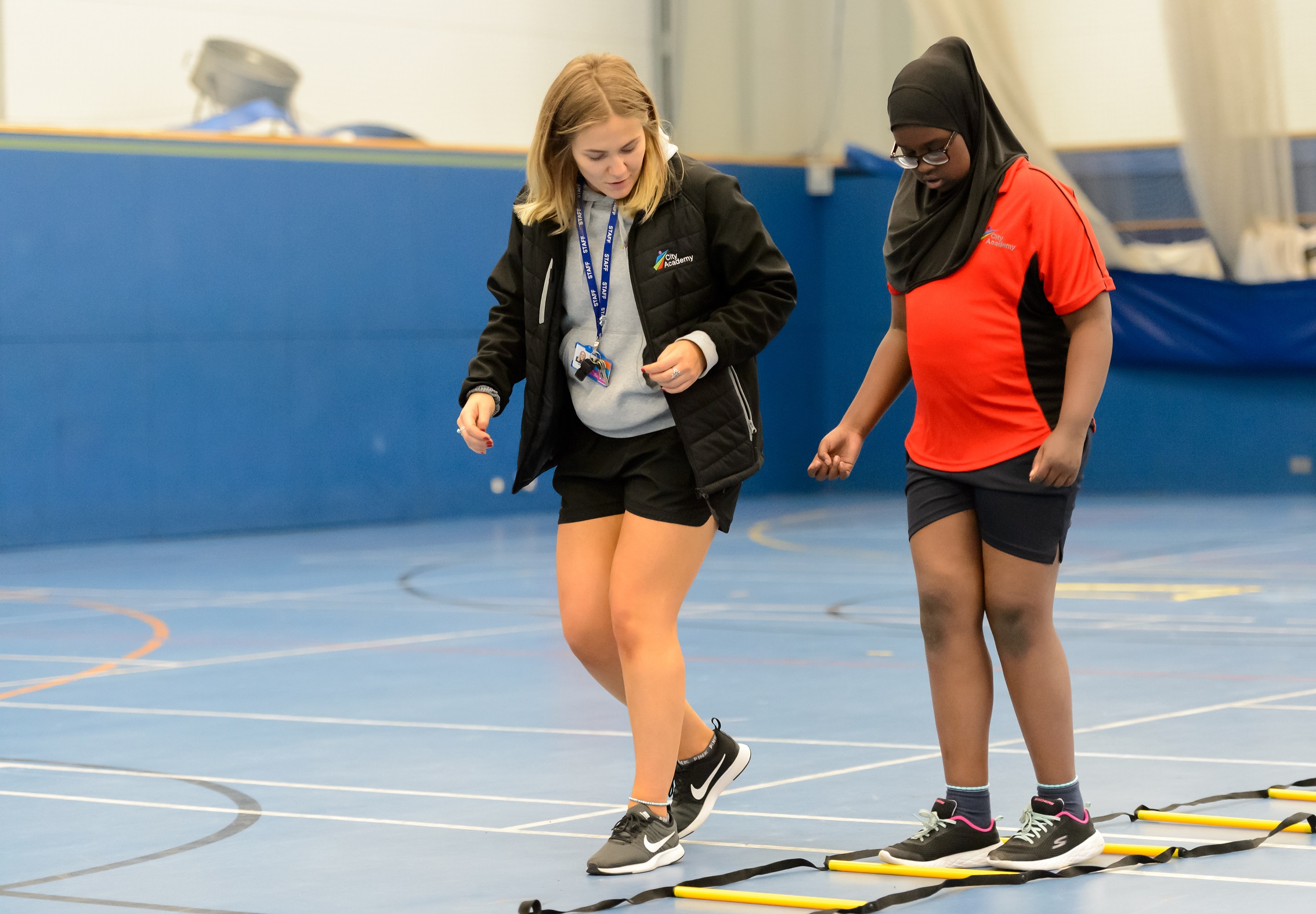 girl coaches student in gym