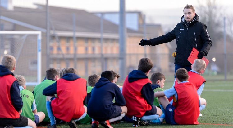 Male football coach with boys