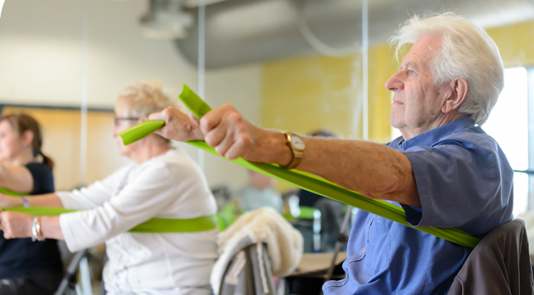 Older man using resistance bands as a group workout