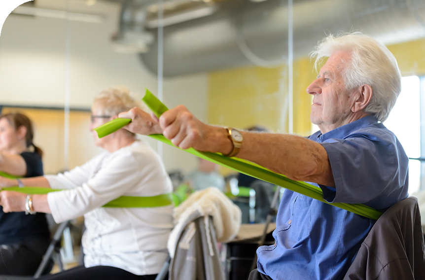 Older man using resistance bands as a group workout