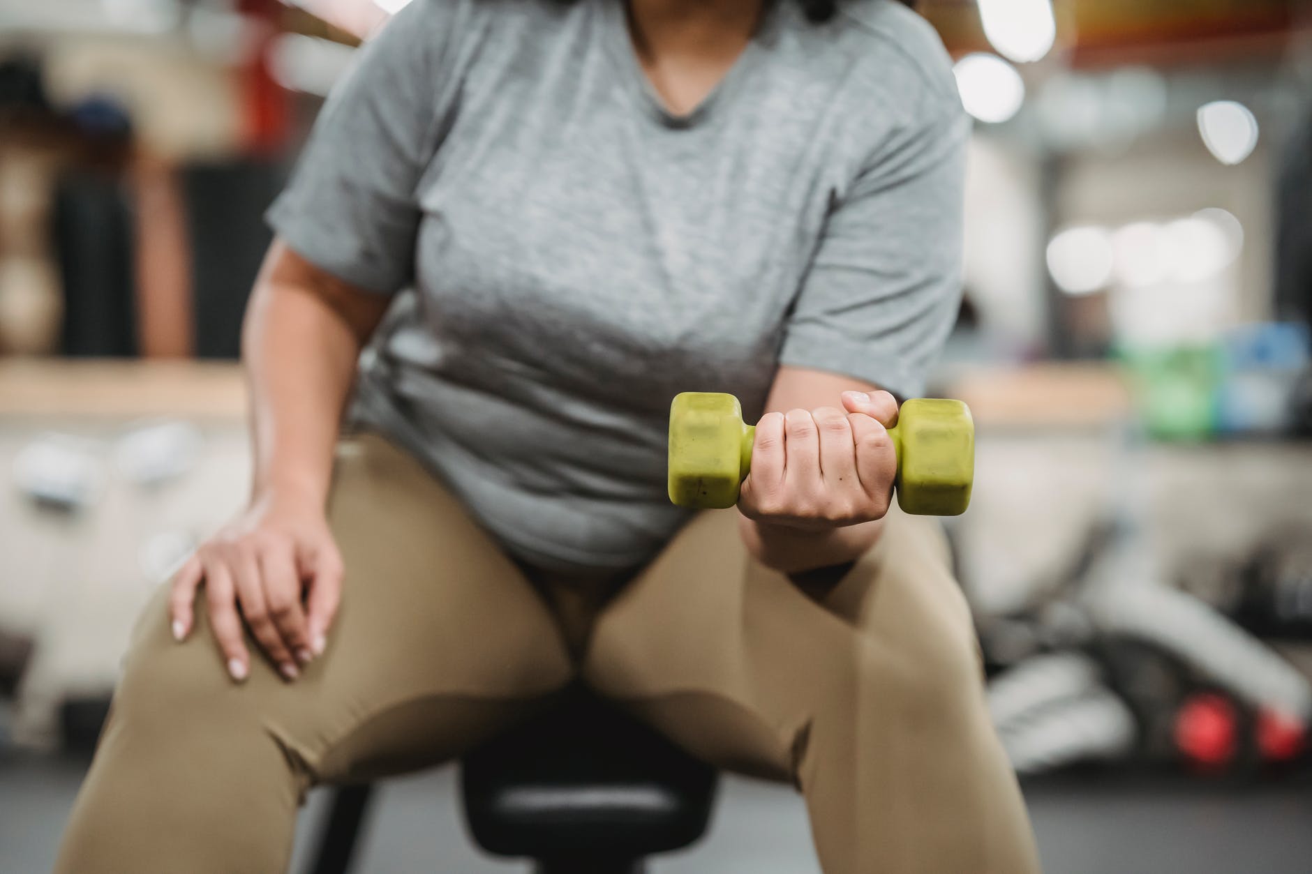 overweight person lifting a handweight for health