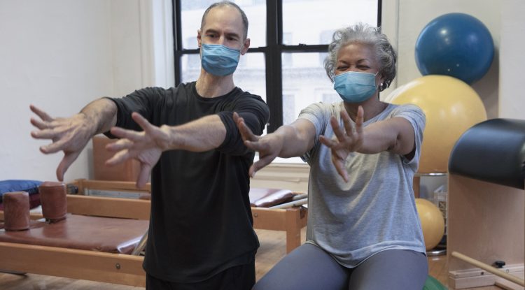 physio and woman exercising with masks