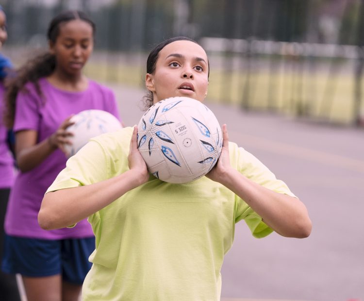 young girl playing netball