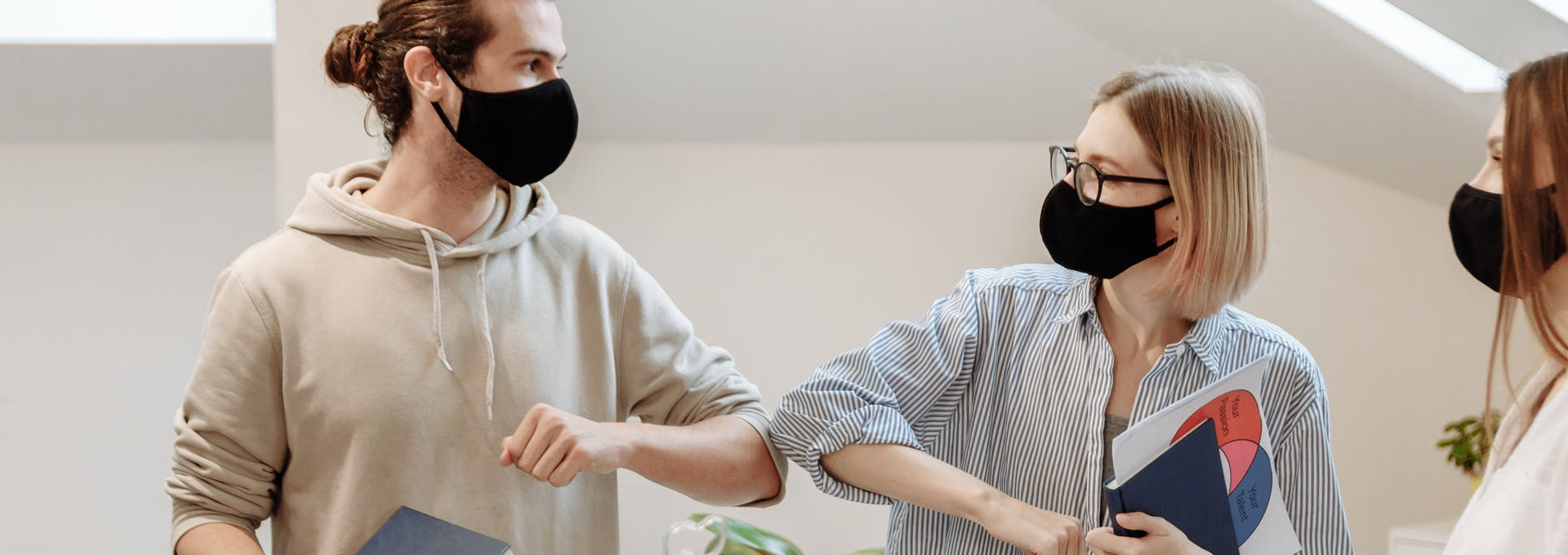 Two employees bumping elbows in the workplace