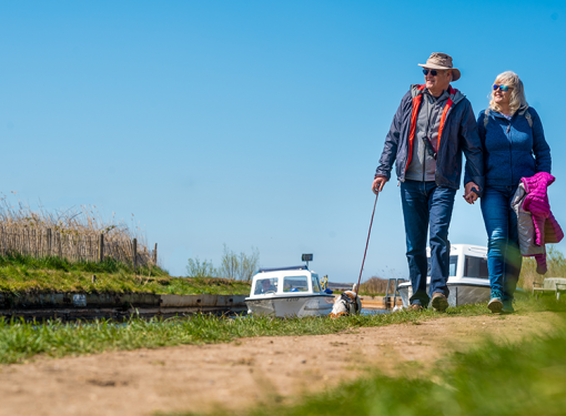 Older couple walking along Norfolk broad