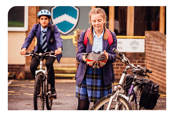 secondary student putting on bike helmet