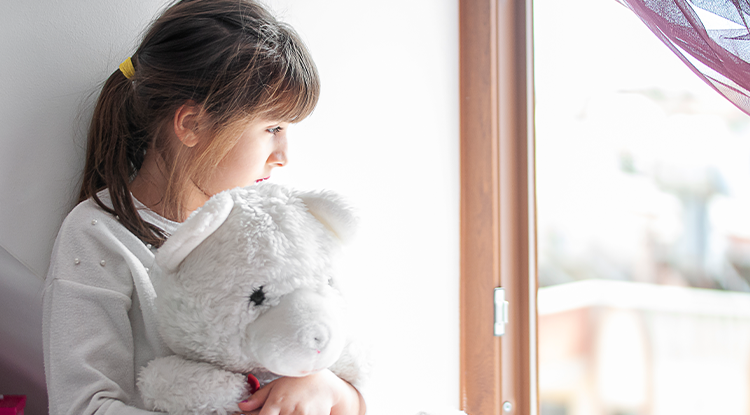 young girl hugging teddy bear