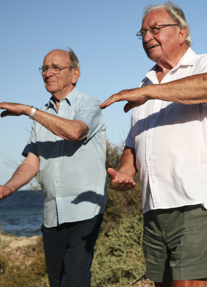 Seniors doing tai chi on the beach