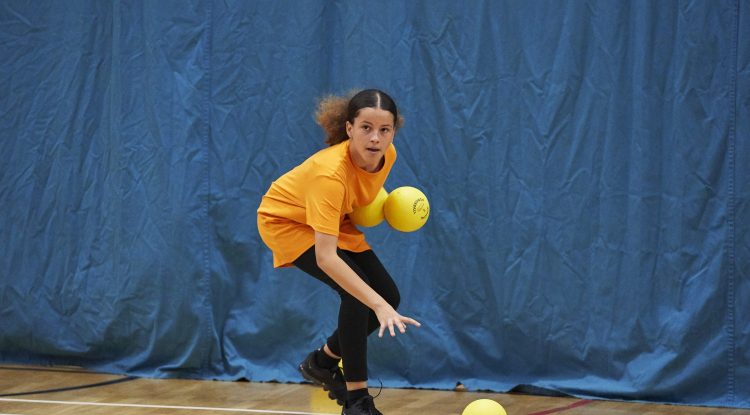 young girl plays dodgeball