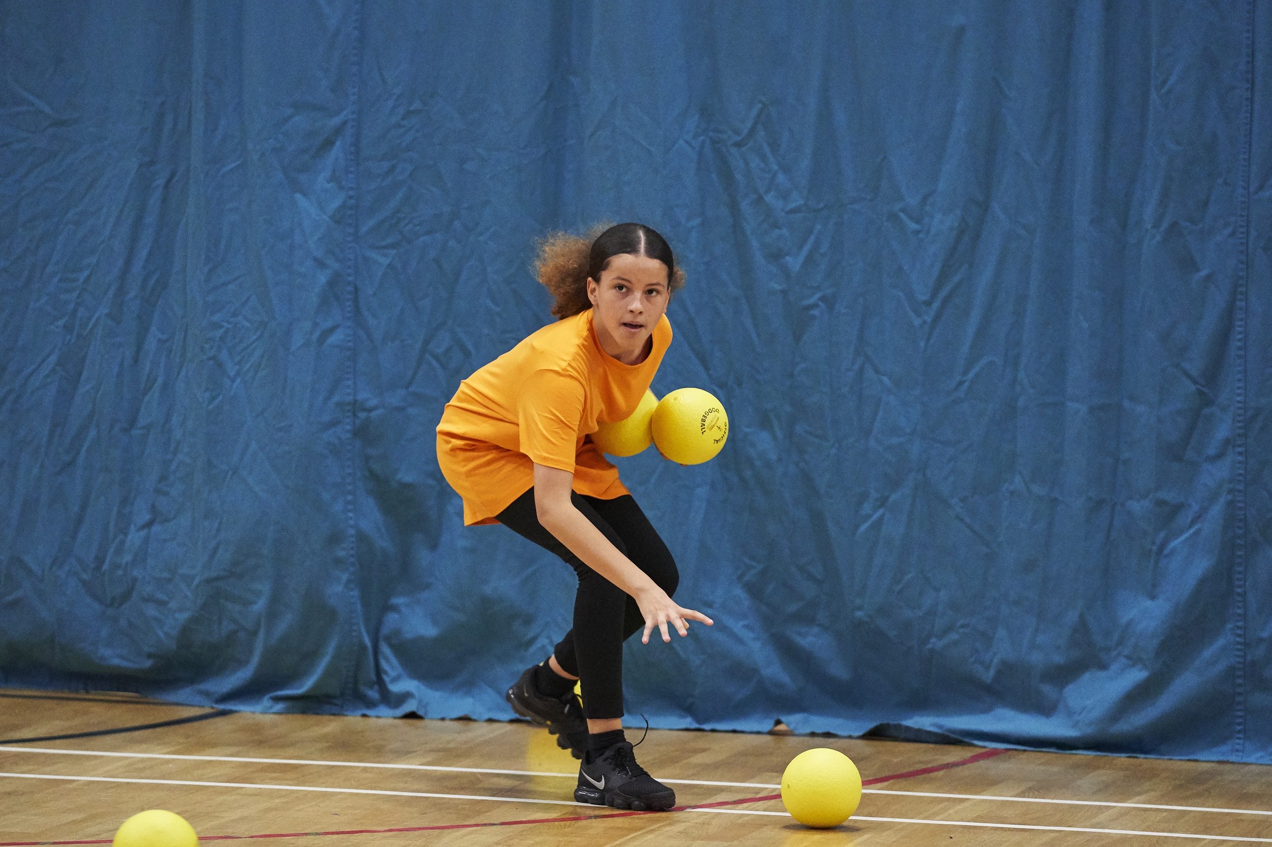 young girl plays dodgeball