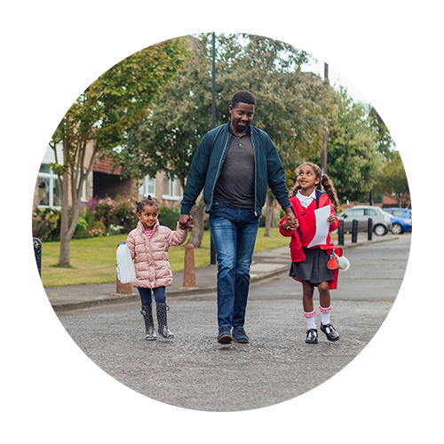 Dad and two daughters walking home from school