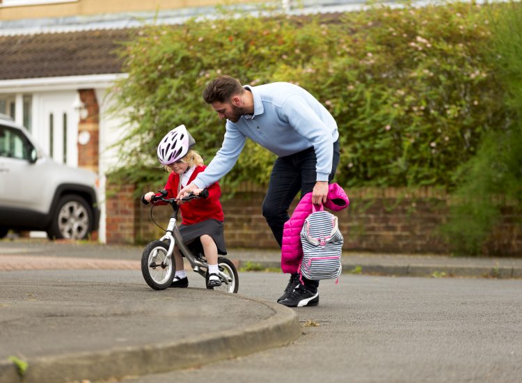 Father and daughter travelling actively to school