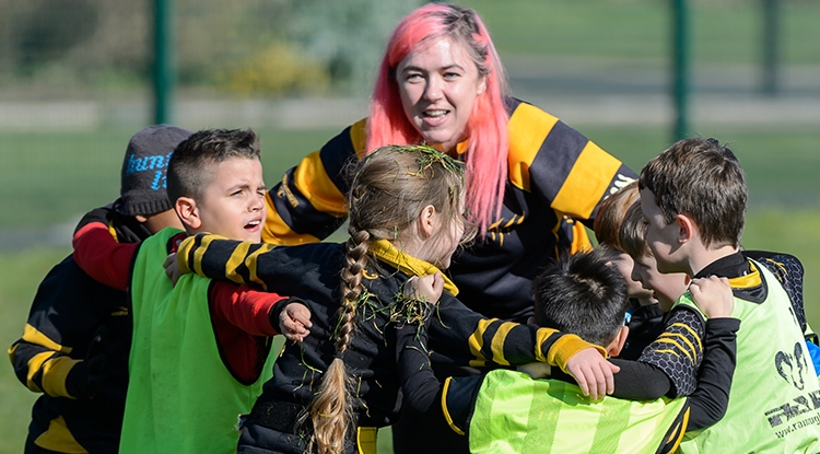 lady coaching a team of young people